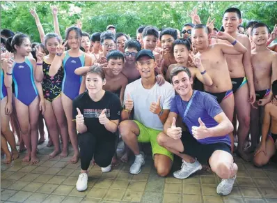  ?? GUO CHENG / XINHUA ?? Chinese swimmers Sun Yang (center), Ye Shiwen (left) and British diver Tom Daley pose with students at a swimming and diving clinic held on the sidelines of Saturday’s FINA World Aquatics Gala in Sanya, Hainan province.