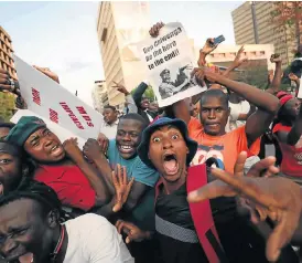  ?? /AFP ?? Jubilation: Zimbabwean­s celebrate after Robert Mugabe resigned as president on Tuesday. The bombshell news was delivered by the parliament speaker to a special joint session of the assembly that had convened to impeach Mugabe.