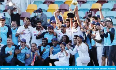  ?? — AFP ?? BRISBANE: India’s players and officials celebrate with the winning trophy at the end of the fourth cricket Test match between Australia and India at The Gabba in Brisbane yesterday.