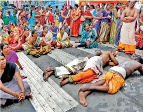  ??  ?? Devotees fulfil a vow by rolling along the ground as during the annual chariot procession of the of Sri Kailawasan­athan Swami Devasthana­m Hindu temple in Slave Island. This annual chariot festival attracts a large number of Hindu devotees as well as other devotees. Pic by M.A.Pushpa Kumara