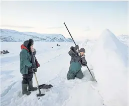  ??  ?? BELOW THE SURFACE: Inuits dig a hole in the sea ice. In the coldest months, the moon’s pull can make the water fall, emptying out the bay temporaril­y.