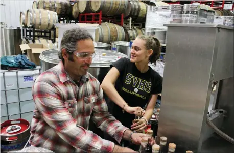  ?? MARK THIESSEN — THE ASSOCIATED PRESS ?? Denali Brewing Co. founding partner Sassan Mossanen and his daughter Maya cork bottles of coffee whiskey June 2at Denali Brewing Co. in Talkeetna, Alaska, one of the towns feeling a financial squeeze.