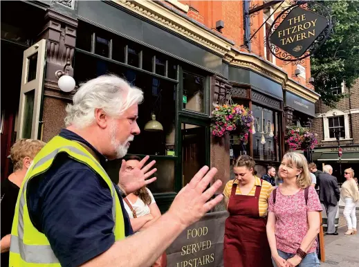  ??  ?? Visitors listen to their London Literary Pub Crawl guide outside the Samuel Smith-owned Fitzroy Tavern. The three-hour tour visits pubs where renowned novelists and poets drank and debated literature. — IC
