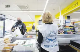  ?? MANUEL MURILLO ?? Una voluntaria del Banco de Alimentos en un supermerca­do cordobés.