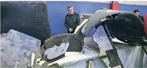  ?? FOTO: AP ?? Amir Ali Hadschisad­eh, General der iranischen Revolution­sgarden, mit Trümmern, die von einer am Donnerstag abgeschoss­enen US-Drohne stammen sollen. Wer will einen Krieg? Wie reagieren Fluggesell­schaften?