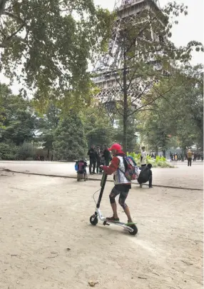  ?? Carolyn Said / The Chronicle ?? British tourist Sarah Westley rides a Lime scooter past the Eiffel Tower. The scooter firms have not had the problems in Paris that they have in San Francisco.