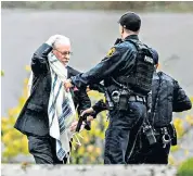  ??  ?? A member of the Tree of Life synagogue’s congregati­on is led away after the shooting