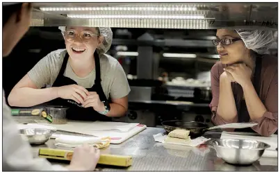  ?? NWA Democrat-Gazette/CHARLIE KAIJO ?? Medical student Emily Weldon (right) and pharmacy student Khusbu Bhikha take directions from chef instructor Erin Szopiak (left) during a cooking class Oct. 29 at Brightwate­r in Bentonvill­e.