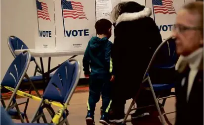  ?? SUZANNE KREITER/GLOBE STAFF ?? At the Amherst Street School in Nashua, Stephanie Valeras voted under the watchful eye of her 3-year-old son, Noah.