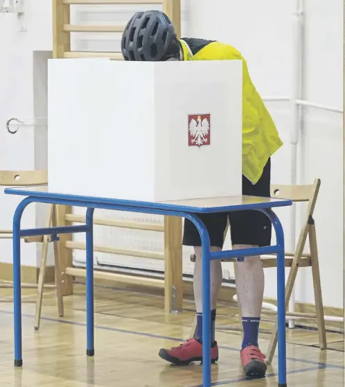  ?? ?? A man casts his ballot in a school gym in Warsaw during local elections in Poland yesterday. Inset: Prime Minister Donald Tusk