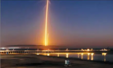  ?? THE ASSOCIATED PRESS ?? Two streaks in this long exposure photo show a SpaceX Falcon 9 rocket lifting off, left, from Vandenberg Air Force Base, as seen from Pismo Beach Sunday and then its first stage returning, right, to Earth at a nearby landing pad. The primary purpose of the mission was to place the SAOCOM 1A satellite into orbit, but SpaceX also wanted to expand its recovery of first stages to its launch site at the Air Force base, about 130 miles northwest of Los Angeles.