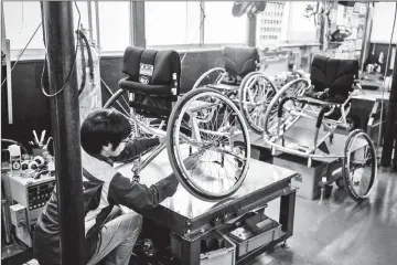  ??  ?? Working on a wheelchair at the OX factory.