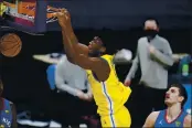  ?? DAVID ZALUBOWSKI — THE ASSOCIATED PRESS ?? Golden State Warriors center James Wiseman hangs from the rim after a dunk, next to Denver Nuggets center Nikola Jokic during the second half Thursday in Denver.