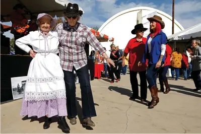  ??  ?? above:
Jo Nash, 94, left, and her friend Pat Jones, 80, dance to the music of the Bakersfiel­d All-Star Band featuring Jimmy Phillips during the Dust Bowl Festival at Weedpatch Camp. Nash and her family migrated to the area from Oklahoma in the 1940s, and she grew up at the camp.