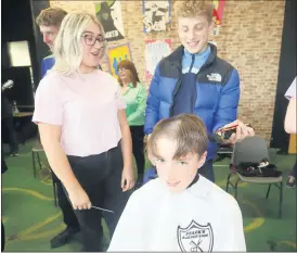  ?? (Pic: Sean Burke) ?? Jack Moher, student council rep, getting his head shaved by peer Jamie Fitzgerald, under the guidance of Maeve Rice.