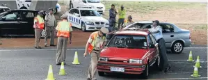  ?? / LEN KUMALO. ?? Police stop motorists during a road block and stop-and-search of vehicles on the highway.