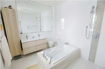  ?? PHOTOS; TONY CALDWELL ?? The bathroom has a European feel with its free-standing shower and soaking tub.