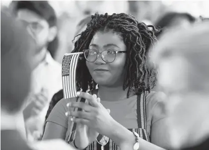  ?? PAUL W. GILLESPIE/CAPITAL GAZETTE ?? New citizen Tongwa Aka, from Cameroon, applauds and smiles after taking the Oath of Allegiance. Twenty-two people became naturalize­d citizens during a ceremony on the Fourth of July at William Paca House.