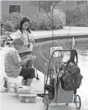  ??  ?? A couple sets up their lines to fish at Veterans Oasis Park in Chandler.