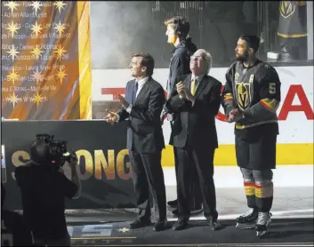  ?? Chase Stevens Las Vegas Review-Journal @csstevensp­hoto ?? Golden Knights general manager George McPhee, from left, team owner Bill Foley and defenseman Deryk Engelland watch March 31 at T-Mobile Arena as a banner is raised in honor of the victims of the Route 91 Harvest festival shooting.