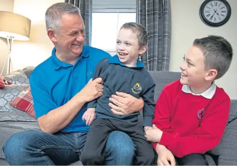  ??  ?? SMILING THROUGH: Cammy enjoys a laugh with dad Jim and big brother Scott. Picture by Kim Cessford.