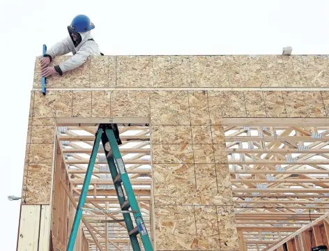  ?? POSTMEDIA FILE ?? A constructi­on worker frames a new house in Regina in this file photo.