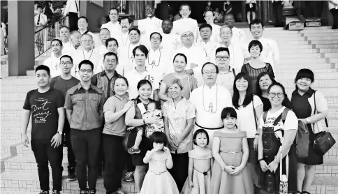  ??  ?? Tay (second row, fourth right) in a group photo with his family and the priests.