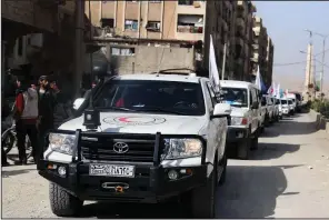  ?? AP ?? This photo released by the Syrian Red Crescent shows a convoy of Red Crescent vehicles arriving in Douma, eastern Ghouta, a suburb of Damascus, on Monday.
