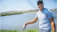  ?? MERY GRANADOS ?? Un pescador muestra uno de los peces que sacó del lago.