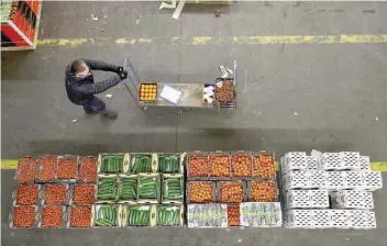  ?? — Reuters ?? A visitor moves a trolley past fruit and vegetables on display at the New Covent Garden market in London.