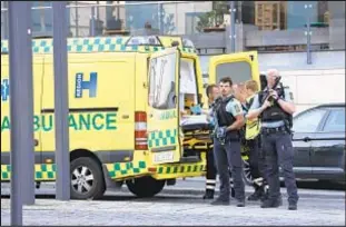  ?? AP ?? Medical workers and police gather outside Field’s shopping center in Copenhagen, site of a mass shooting Sunday. A casualty count has not been released.