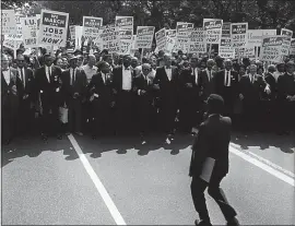  ?? NATIONAL ARCHIVE — NEWSMAKERS/HULTON ARCHIVE/GETTY IMAGES/TNS ?? The author notes that racists and those who perpetuate unfair employment practices participat­e in and are an integral part of costing the United States trillions of dollars yearly. Here, Rev. Martin Luther King and other civil rights leaders march at a civil rights rally Aug. 28, 1963, in Washington, D.C.