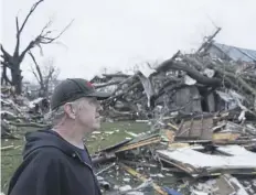  ?? PICTURE: AP PHOTO/JOSHUA A. BICKEL ?? Greg Mcdougle walks near debris, following a deadly storm in Ohio yesterday