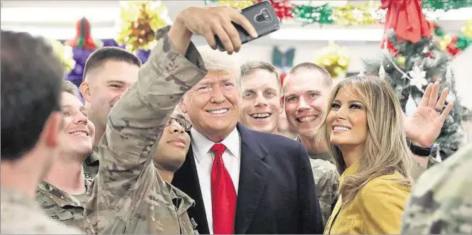  ??  ?? ENCANTADOS. Soldados estadounid­enses toman selfies de su encuentro con el presidente Donald Trump y la primera dama Melania, en la Base Aérea Al Asad, en Irak. Los militares valoraron el gesto.