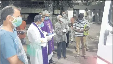  ?? CEDRIC PRAKASH VIA AP ?? Priests pray over the body of the late Rev. Jerry Sequeira before his cremation in Ahmedabad, India. Sequeira is one of more than 500 Catholic priests and nuns who have died from COVID-19 in India, according to the Rev. Suresh Mathew.