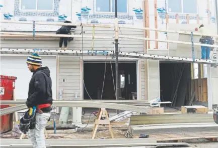  ?? AAron Ontiveroz, The Denver Post ?? Constructi­on workers put siding on a new home at the Brookfield Residentia­l Properties developmen­t at West 67th Avenue and Pecos Street.