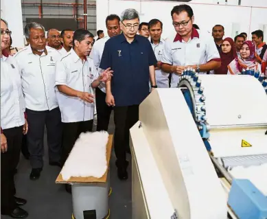  ??  ?? Futuristic equipment: Officials briefing Mah on the Kenaf processing machine after the opening ceremony of the Fibre and Biocomposi­te Centre (Fidec 3) and furniture durability testing laboratory at the Olak Lempit furniture complex in Banting. — Bernama