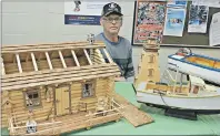  ?? TC MEDIA PHOTO ?? An incredible log cabin dollhouse made by Georges Arsenault. Details down to the dollhouse lamp, rocking chair, shingles on the roof, rifle, axe, oars, miniature furniture, stone fireplace to name but a few, were not overlooked in the creation of the...