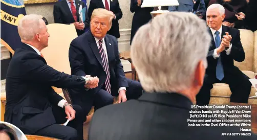  ?? AFP VIA GETTY IMAGES ?? US President Donald Trump (centre) shakes hands with Rep Jeff Van Drew (left) D-NJ as US Vice President Mike Pence and and other cabinet members look on in the Oval Office at the White
House