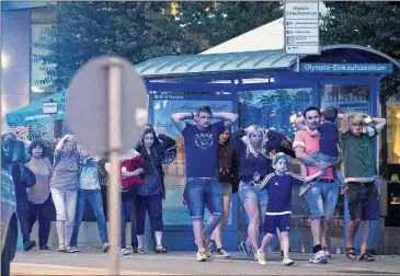  ?? SEBASTIAN WIDMANN / AP ?? People leave the Olympia Einkaufsze­ntrum mall in Munich, southern Germany, on Friday after several were killed or injured in an attack. Authoritie­s called it an act of terrorism.