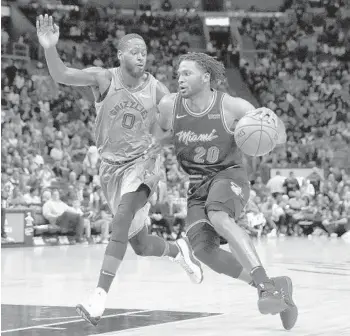  ?? BRYNN ANDERSON/AP ?? Heat forward Justise Winslow dribbles the ball against Grizzlies forward JaMychal Green in Saturday’s Heat victory.