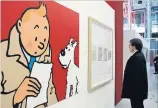  ?? JACQUES BRINON THE ASSOCIATED PRESS ?? A visitor looks at original letters by Belgian cartoonist Herge and an enlarged cartoon of Tintin and his dog Snowy.