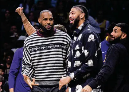  ?? COREY SIPKIN/ASSOCIATED PRESS ?? Lakers forwards Lebron James (left) and Anthony Davis watch from the bench during the second half of a game against the Nets on Jan. 30 in New York. More NBA stars are taking nights off to rest, often frustratin­g fans who paid to see them.