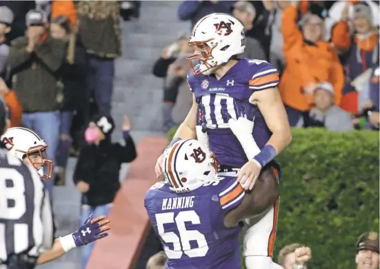  ?? BUTCH DILL/AP ?? Auburn quarterbac­k Bo Nix celebrates with offensive lineman Tashawn Manning after scoring a touchdown against Mississipp­i. He passed for a TD and rushed for two TDs.