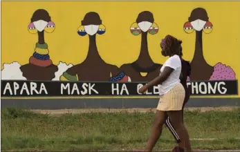  ?? AP
PHOTO/THEMBA HADEBE ?? A woman walks past a coronaviru­s-themed mural promoting the use of face mask in public place, in Sebokeng, Vereenigin­g, South Africa, Thursday.