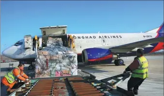  ?? XU CONGJUN / FOR CHINA DAILY ?? Ground staff load cargo at Nantong Airport, Jiangsu province.