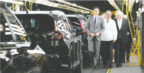  ?? NATHAN DENETTE / THE CANADIAN PRESS ?? From left, Prime Minister Justin Trudeau, Honda executive Toshihiro Mibe and Ontario Premier Doug Ford walk along an assembly line at an event to announce the new Honda electric vehicle assembly plant in Alliston, Ont.