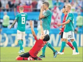  ?? GETTY IMAGES ?? Thomas Mueller of Germany looks dejected after his side’s defeat at the hands of South Korea at Kazan Arena in Kazan, Russia, on Wednesday as a victorious Ju Sejong celebrates.