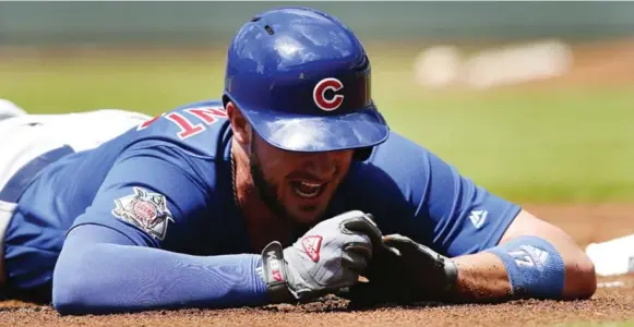  ?? JOHN BAZEMORE/THE ASSOCIATED PRESS ?? National League MVP Kris Bryant of the Cubs doesn’t plan to change his headfirst slide habits despite suffering a sprained finger that lingers, but he likes the idea of softer bases.