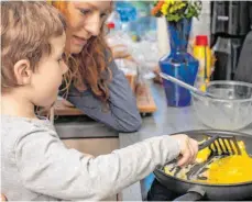  ?? FOTO: CHRISTIN KLOSE/DPA ?? Zu Hause gemeinsam kochen: In vielen Familien ist das Alltag. Dabei lassen sich Hygienereg­eln gut an Kinder vermitteln.